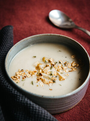 Soep van geroosterde aardpeer met gestoofde peertjes en granolatopping